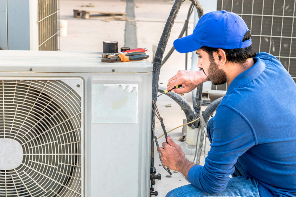 a,professional,electrician,man,is,fixing,the,heavy,air,conditioner